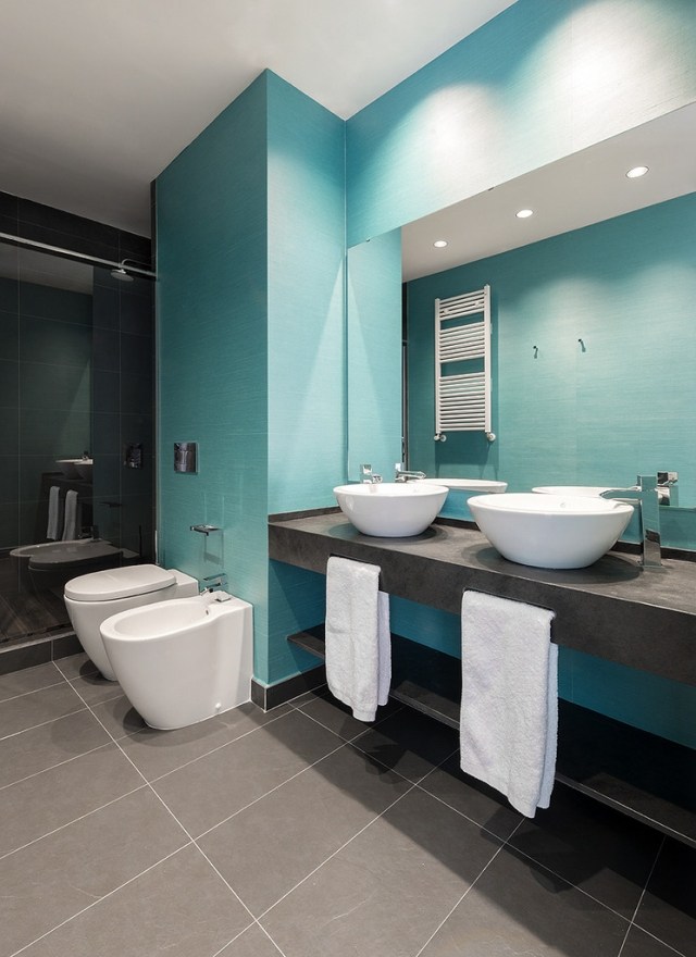 un carrelage de salle de bains en bleu clair et deux vasques blanches