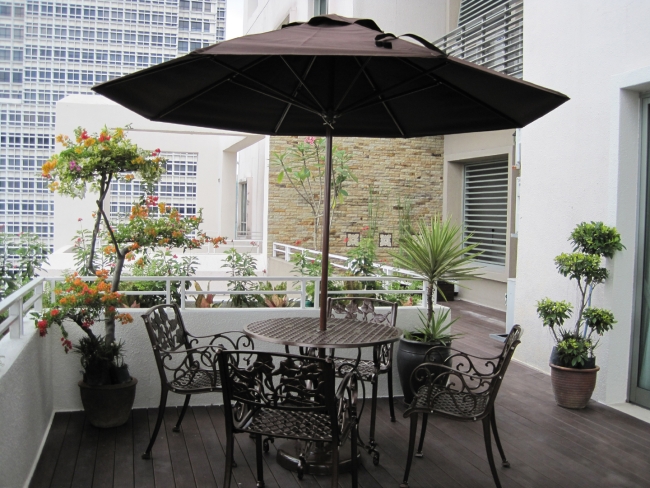 terrasses et patios balcon-urbain-palmiers-mobilier-fer-forgé-parasol