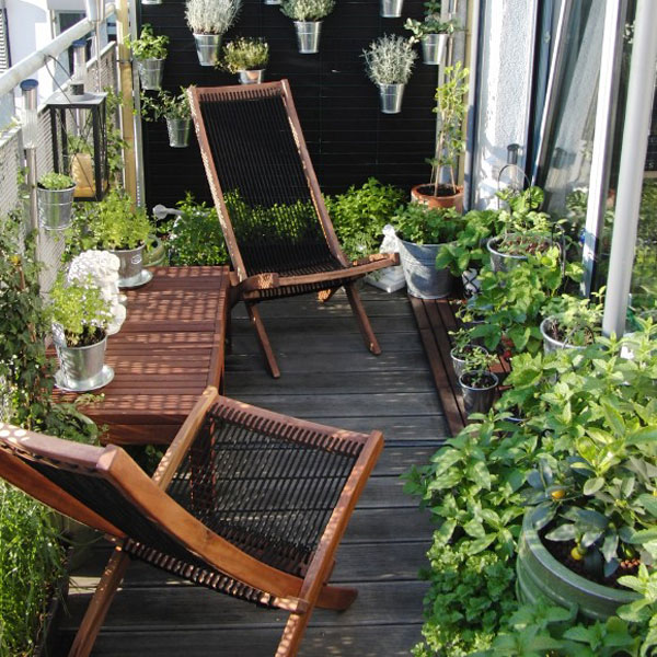 petit-balcon-vert-plantes-luxuriantes-chaises-bois