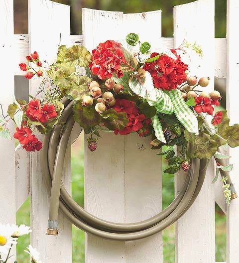 tuyau-arrosage-jardin-décoré-fleurs-clôture-blanche