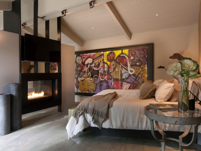 chambre à coucher de luxe chaleureuse-cheminée-chevet-métal-tableau-mural