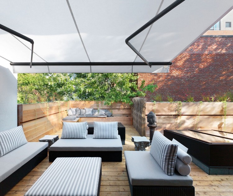 aménagement-balcon-canapé-design-chaises-parasol-sol-bois