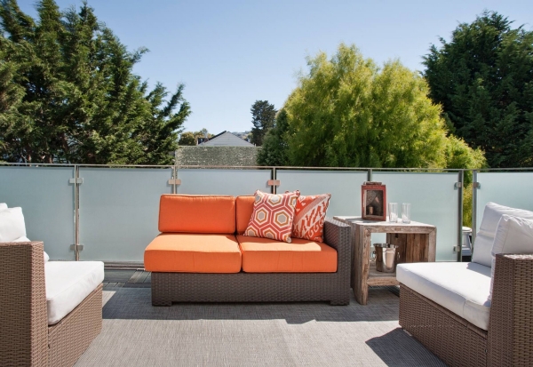 aménagement-balcon-idées-salon-extérieur-meubles-rotin-coussins-orange