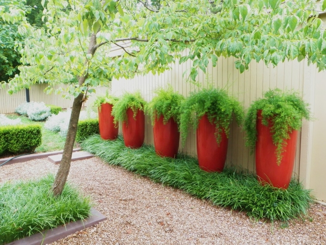 hauts-cache-pots-rouges-forme-ronde-jardin-vert