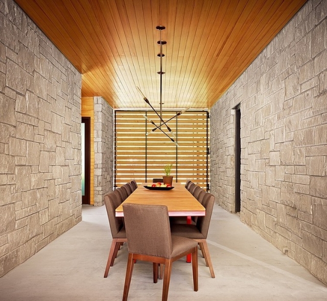 ameublement-salle-manger-idées-revêtement-mural-pierre-naturelle-table-bois-chaises-tapissées