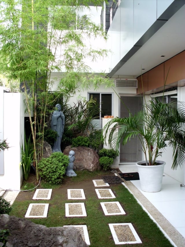 atmosphère-naturelle-jardin-zen-statuettes-plantes-palmier-pelouse