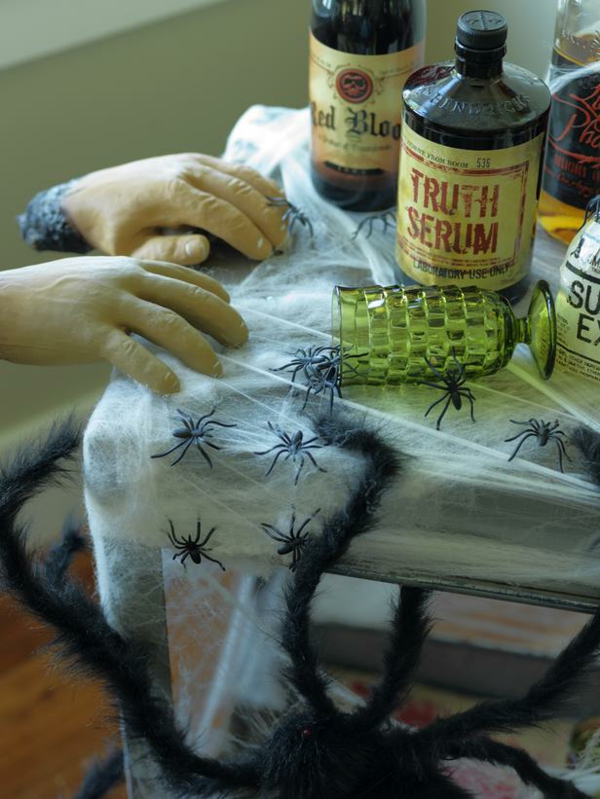 décoration-Halloween-table-idées-uniques-designers-araignées-artificielles-étiquettes-bouteilles décoration Halloween de table