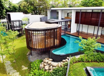 piscine-hors-sol-moderne-forme-asymétrique-bardage-pierre-jardin-gazon