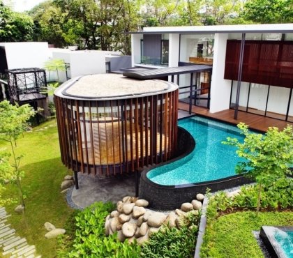 piscine-hors-sol-moderne-forme-asymétrique-bardage-pierre-jardin-gazon