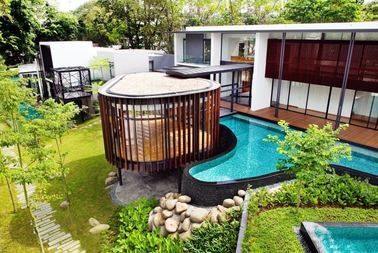 piscine-hors-sol-moderne-forme-asymétrique-bardage-pierre-jardin-gazon