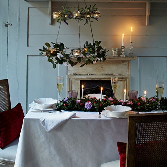 déco de table pour Noël 35-idées-déco-table-Noël-lustre-feuilles-bougies-nappe-blanche-coussins-rouges-bougeoirs-argentés déco de table pour Noël