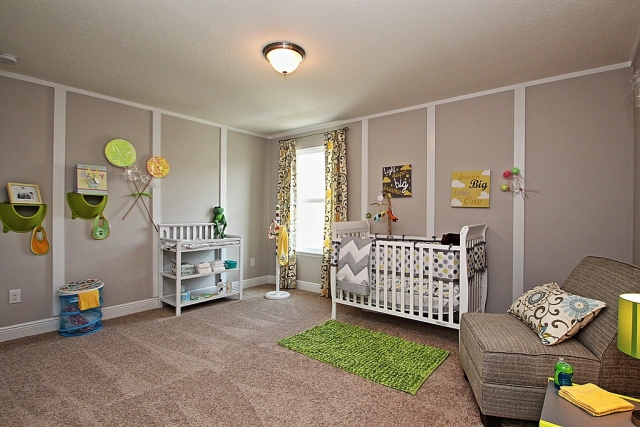 chambre bébé chambre-bébé-déco-mobilier-tapis-vert-étagères-vertes-rideaux-motifs-fauteuil-gris-rembourré