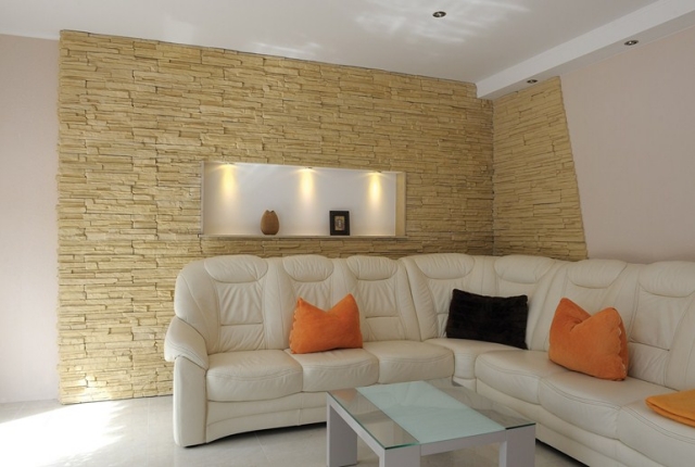 pierre-parement-revêtement-mural-intérieur-décoratif-beige-salon-design-épuré-canapé-blanc-coussins-orange