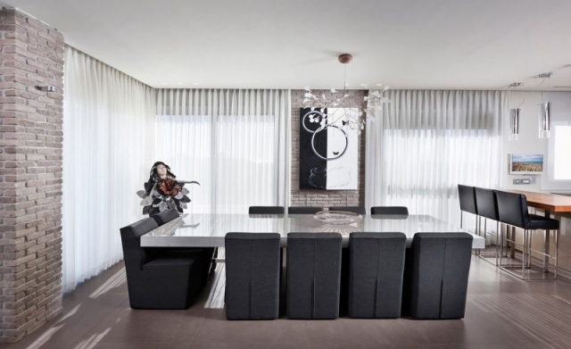 salle-manger-contemporaine-fauteuils-noirs-mur-briques