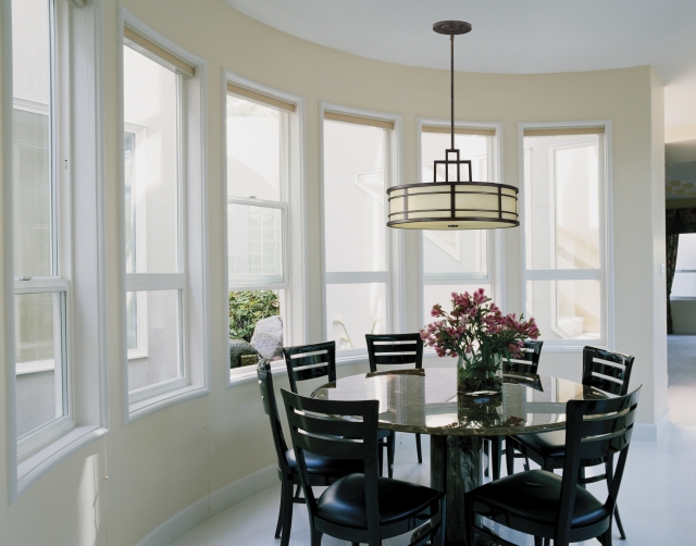 salle-manger-contemporaine-table-ronde-élégante-chaises-noires-tapissées-lustre