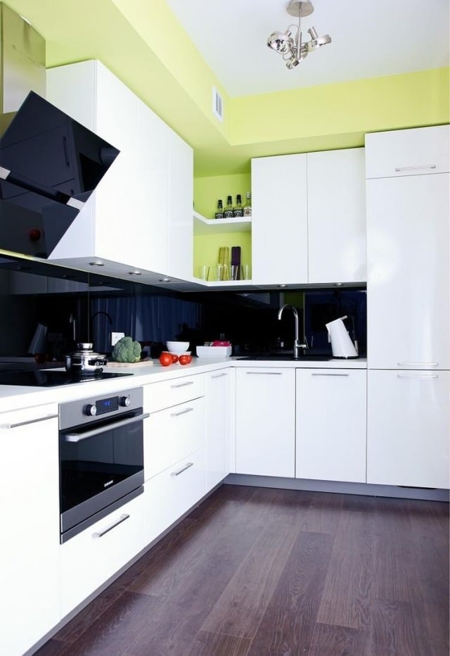 armoires de cuisine blanches crédence noire murs vert pistache
