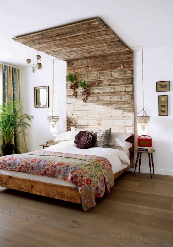 chambre-à-coucher-grand-lit-coussins-couverture-revetement-bois