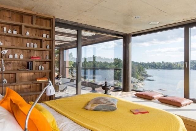 chambre-coucher-moderne-couverture-jaune-coussins-orange-bibliothèque-bois-grandes-fenêtres