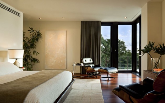 chambre-coucher-moderne-literie-blanc-beige-rideaux-plissés-élégants-fauteuil-relax-cuir-noir-tapis-blanc