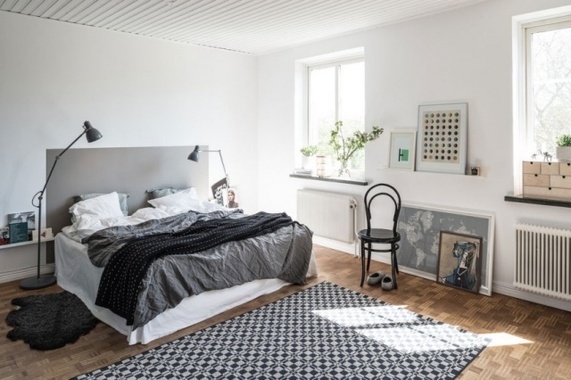 chambre-coucher-moderne-literie-blanc-gris-noir-lampes-sol-élégantes-métalliques-tapis-noir-blanc chambre à coucher contemporaine