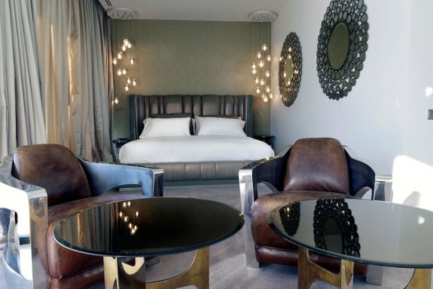chambre-coucher-moderne-miroirs-élégants-noirs-murs-grand-lit-tête-lit-tapissée-aspect-cuir-fauteuils-cuir-marron chambre à coucher contemporaine