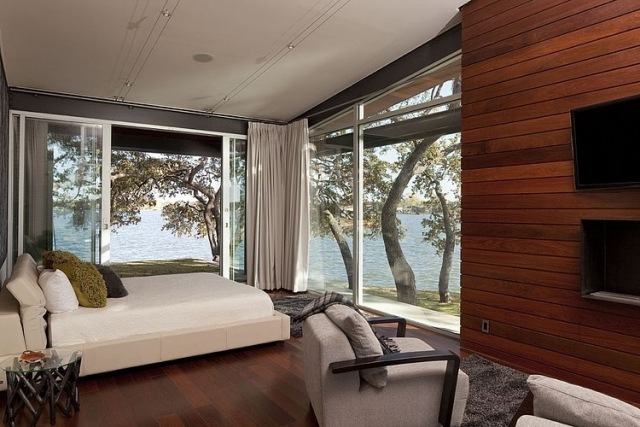 chambre-coucher-moderne-revêtement-mural-bois-grandes-fenêtres-coussins-décoratifs chambre à coucher contemporaine