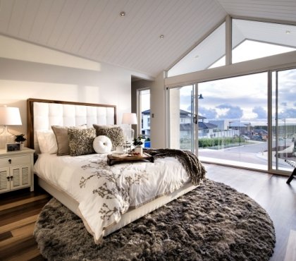 chambre-coucher-moderne-tapis-rond-poils-longs-lit-grand-coussins-décoratifs-lampe-chevet-blanche