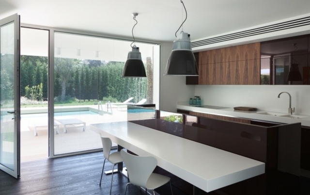 cuisine-moderne-chaises-blanches-table-moderne-blanc-marron-suspensions-métalliques-armoires-bois cuisine moderne