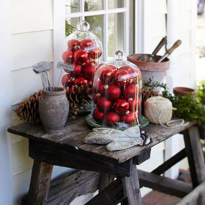 décoration-Noël-extérieur-boules-Noël-rouges-cloches-verre-table-bois-jardin-pommes-pin décoration de Noël extérieur