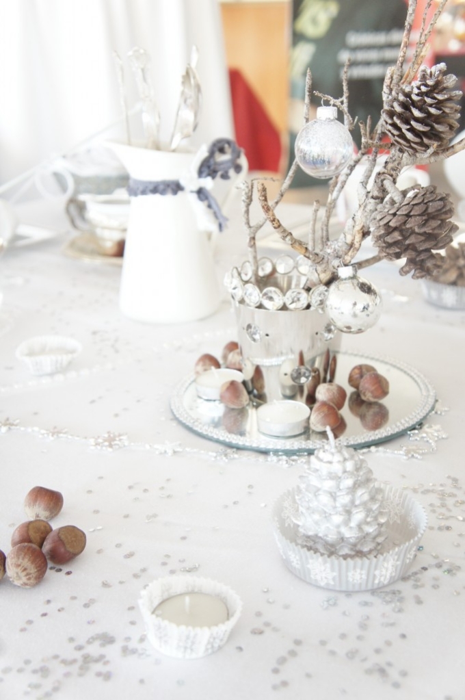 décoration-table-Noël-arrangement-pommes-pin-branches-boules-noix-nappe-blanche