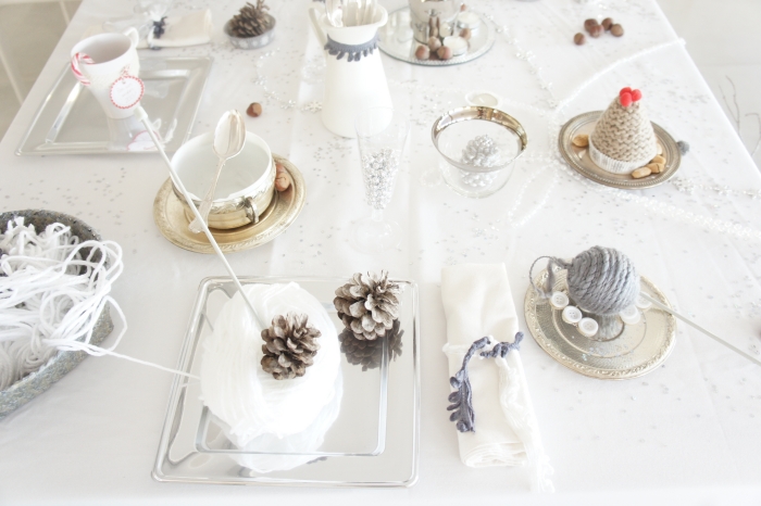 décoration-table-Noël-pommes-pin-nappe-blanche-boules-décoratives-serviettes-blanches décoration de table