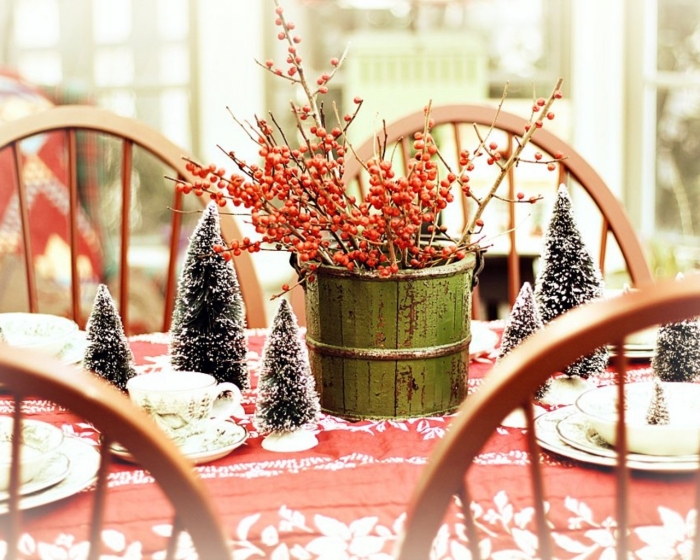 décoration-table-Noël-sapins-décoratifs-neige-artificielle-arrangement-branches-baies-rouges-nappe-rouge-blanc décoration de table