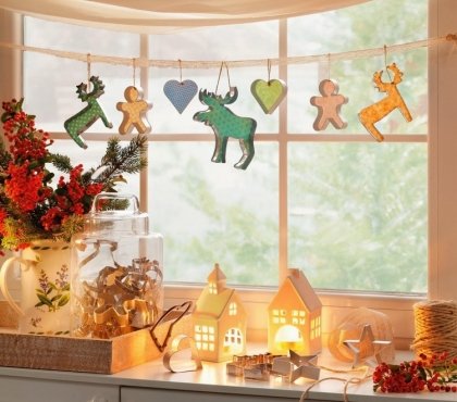 déco-fenêtre-Noël-guirlande-formes-biscuits-petites-maisons-blanches-bougeoirs