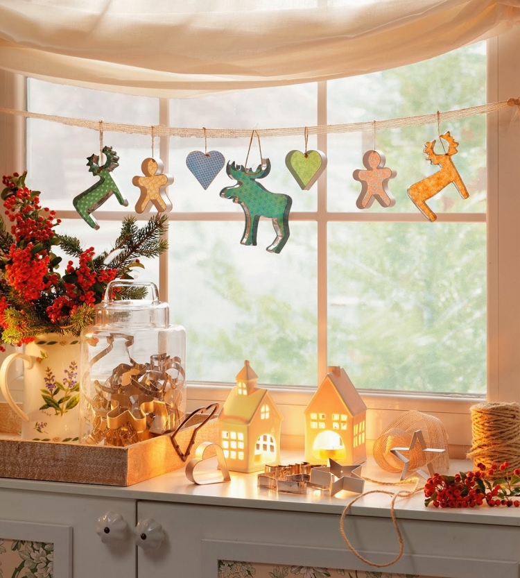 déco-fenêtre-Noël-guirlande-formes-biscuits-petites-maisons-blanches-bougeoirs