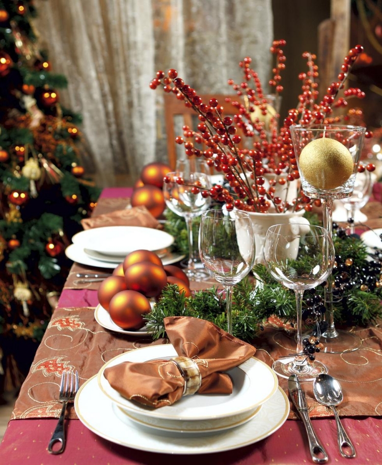 déco-table-Noël-boules-Noel-orange-chaud-serviette-marron-rond-serviette-or-branches-baies-rouges