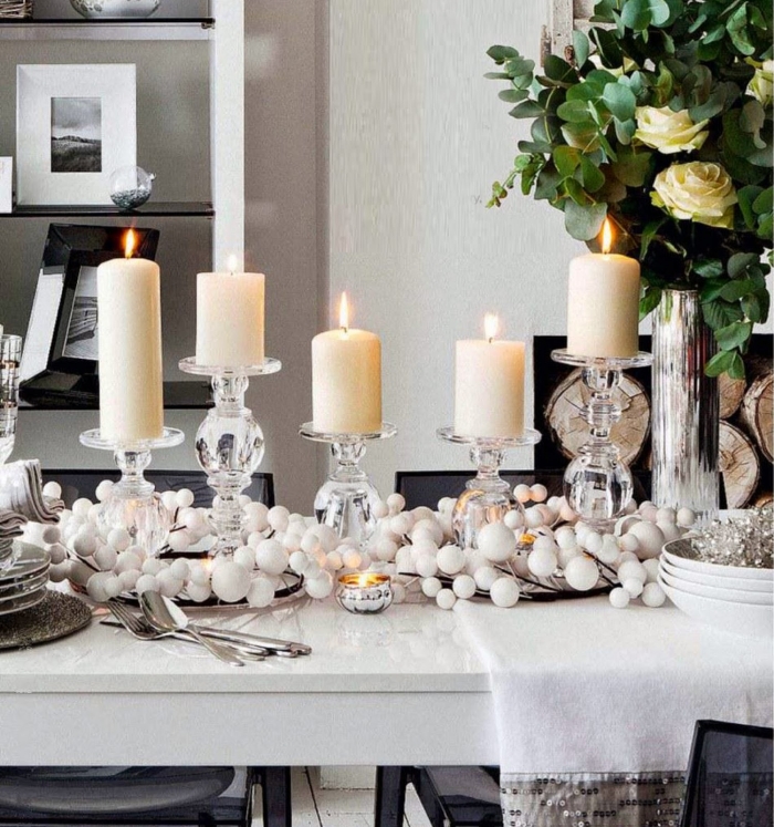 décoration-table-Noël-bougies-blanches-guirlandes-boules-blanches-bougeoirs-cristal