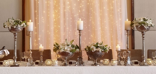 décoration-table-Noël-thème-hiver-bougies-blanches-arrangements-fleurs-bougeoirs-argent