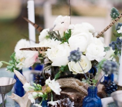 décoration-table-Noël-thème-hiver-plumes-vases-verre-bleu-pommes-pin-ornements-blancs