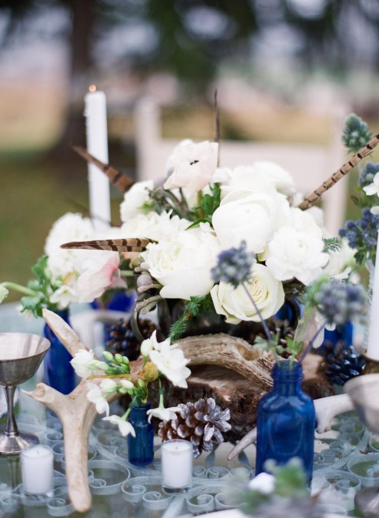 décoration-table-Noël-thème-hiver-plumes-vases-verre-bleu-pommes-pin-ornements-blancs