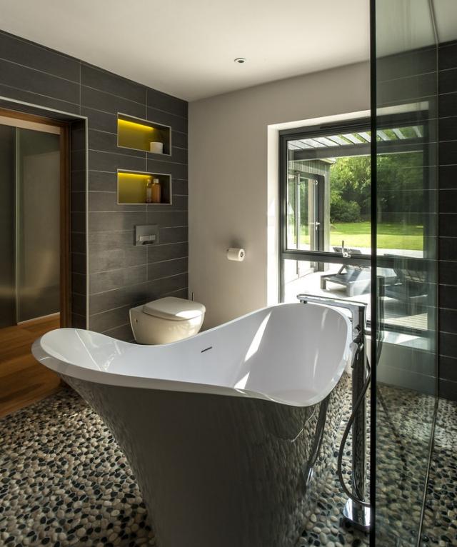salle-bains-moderne-baignoire-îlot-pierre-décorative-sol-carrelage-mural-noir-mat