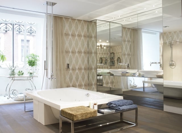 salle-bains-moderne-carrelage-beige-motifs-blancs-baignoire-îlot-banc-métallique-paroir-miroir
