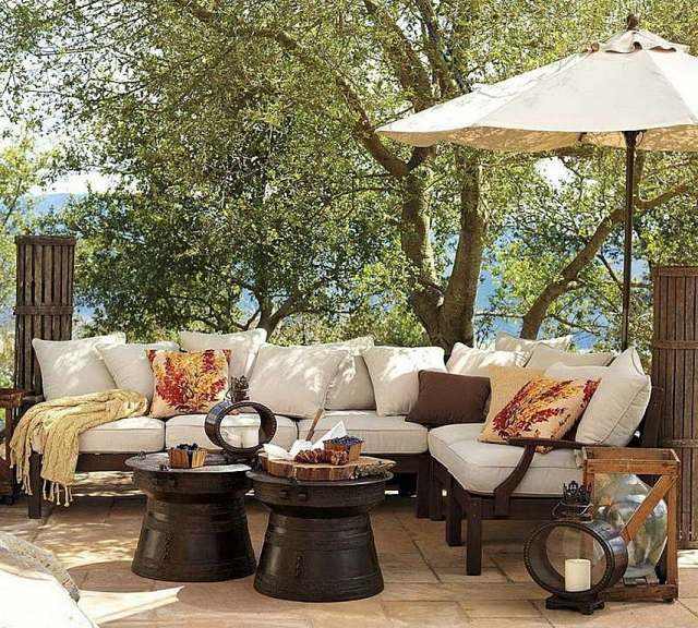 aménagement-terrasse-idee-originale-canape-agnle-coussins-parasol-table-ronde