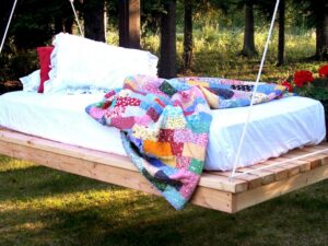 lit-suspendu-bois-matelas-couverture-multicolore