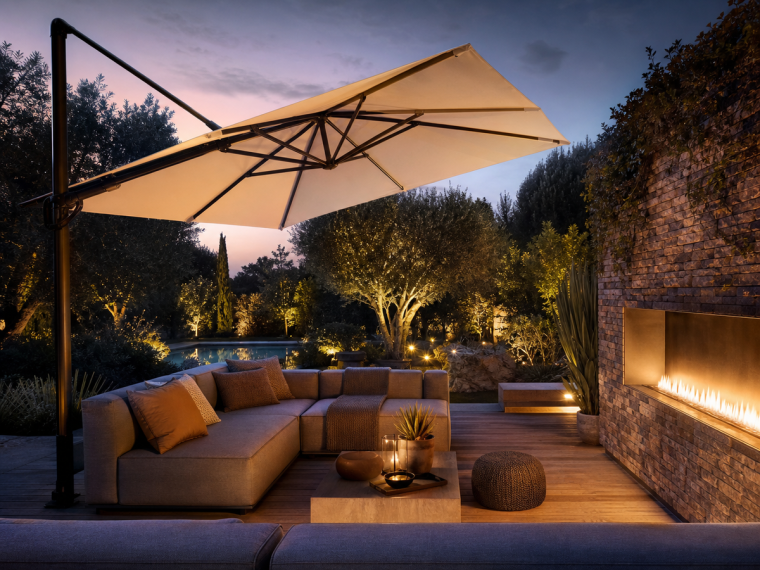 Terrasse élégante avec parasol déporté inclinable et cheminée linéaire au crépuscule