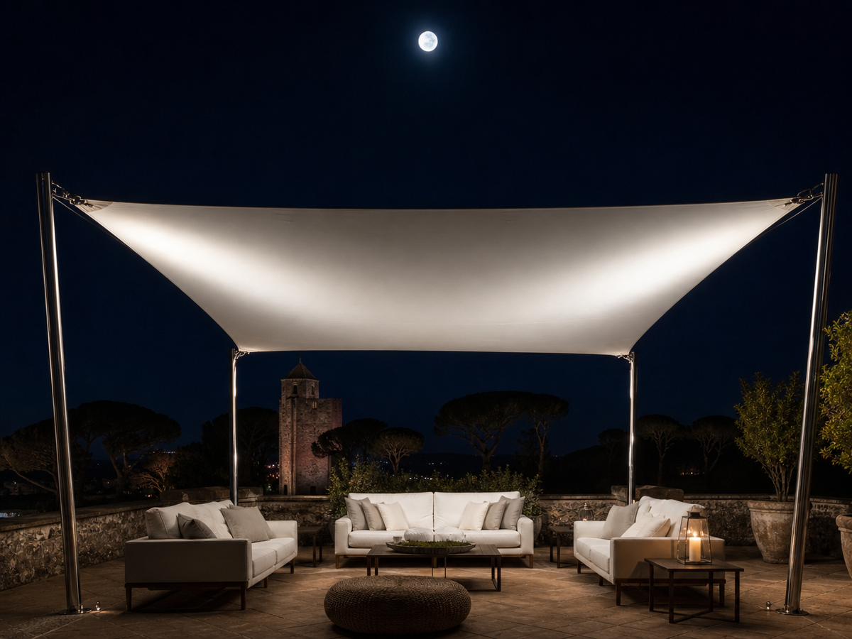 Voile d'ombrage autoportant rectangulaire blanc sur terrasse de nuit avec canapés modernes