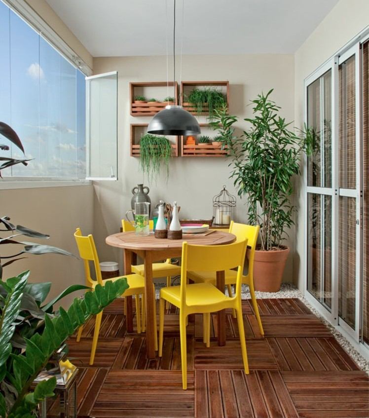 aménagement-balcon-table-ronde-chaises-jaunes-sol-bois-composite