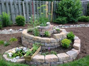 aménagement-jardin-spirale-aromatique-pierres-jardiniere-herbes
