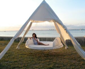 lit-suspendu-rond-tente-blanche-jardin-matelas