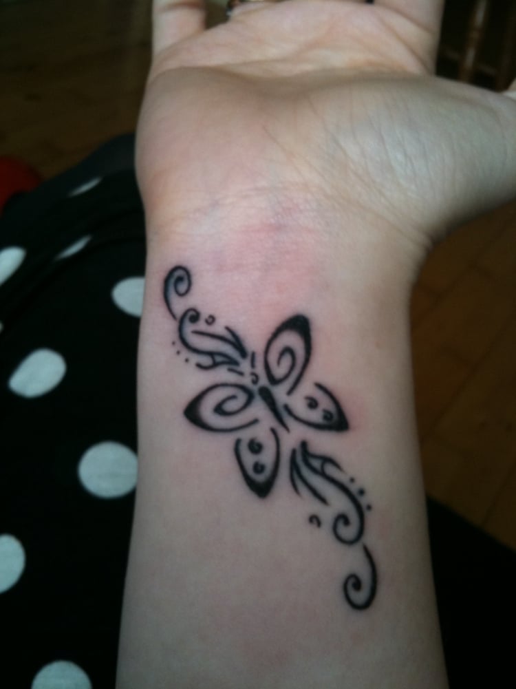 tatouage poignet femme papillon stylisé arabesques