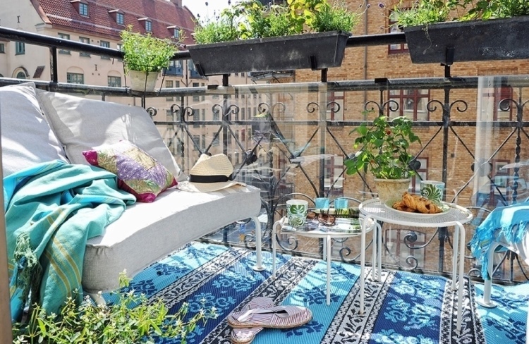 brise-vue-balcon-tapis-ethnique-motifs-bleus-canapé-blanc-coussin-table